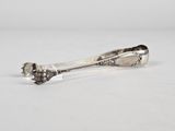 a silver spoon with a flower on it sitting on a white surface