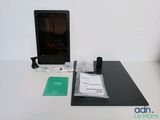 un ordinateur portable posé sur un bureau, à côté d'une tasse