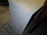 a white refrigerator sitting in a room with a wooden chair