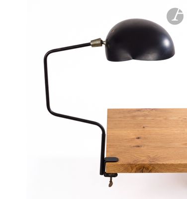 a black desk lamp on a wooden table with a white background