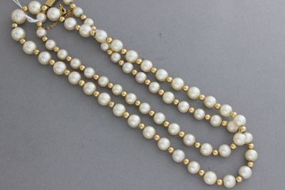 un gros plan sur un collier composé de perles et de perles en or