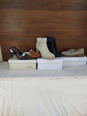 several pairs of women ' s shoes are sitting on boxes on a bed