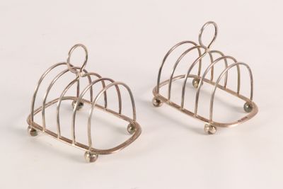 two pairs of silver plated birdcages on a white surface