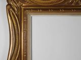 an ornate gold frame with a white wall in the background