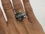 a woman ' s hand holding a ring with three diamonds on it