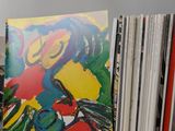a lot of records on a table with a painting on it