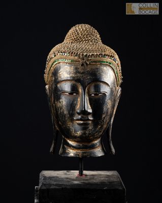 une tête de Bouddha en bronze sur fond noir