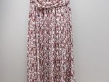 a red and white floral print skirt hanging on a hanger