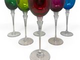 several different colored wine glasses are lined up in a row