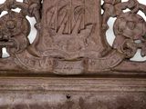 a brown marble plaque with a coat of arms on it