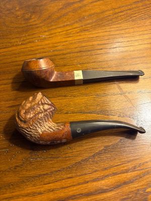 une pipe et un porte-pipe posés sur une table en bois