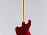 a red electric guitar hanging from a white wall