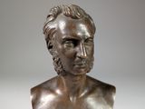 bronze bust of a man with long hair and a beard