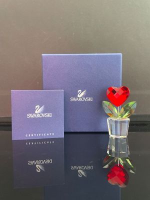 un petit vase en verre contenant une rose rouge