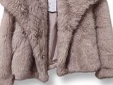 un gros plan d'une veste suspendue à un cintre sur fond blanc