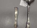 two silver spoons and a spoon rest on a table
