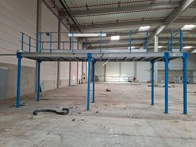 une grande pièce dotée d'une structure métallique et de balustrades bleues