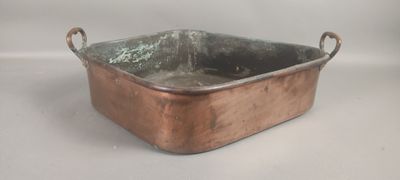 an old copper pan with handles on a white background