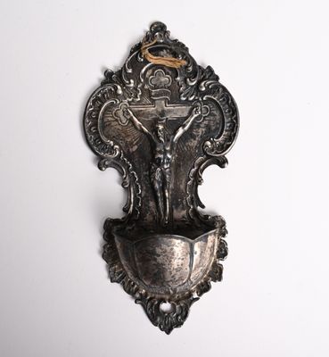 une plaque en argent fixée au mur sur laquelle est représenté un crucifix