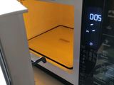 a microwave oven with a yellow tray inside of it