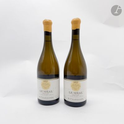 deux bouteilles de vin posées l'une à côté de l'autre sur une surface blanche