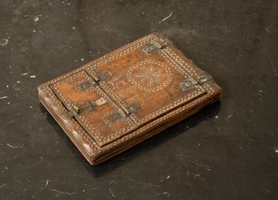an old book sitting on top of a table next to a pair of scissors