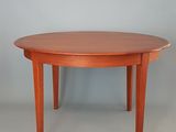 une table à manger ronde avec un plateau et des pieds en bois