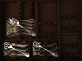 many spoons and forks in a wooden box