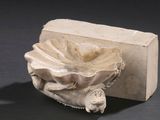 un objet en pierre orné d'une fleur, posé à côté d'un morceau de savon