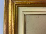 a close up of a picture of a gold frame on a wall