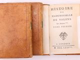 un vieux livre ouvert sur une surface blanche