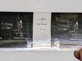 a hand holding a picture of a man in a kitchen