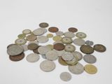 coins are scattered on a white surface with a white background