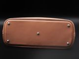a brown leather case with rivets and rivets on a black background