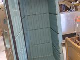 a small open refrigerator sitting in a warehouse with other items