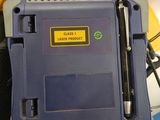 a blue and yellow device sitting on top of a black bag