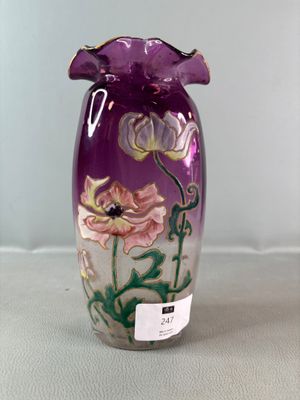 a purple vase with flowers painted on it sitting on a table