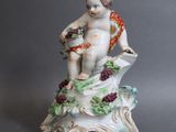 une figurine représentant un garçon tenant un panier de fleurs