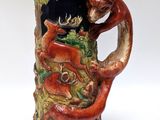 a beer mug with a dragon on it sitting on a table