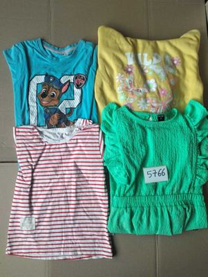 three children ' s t - shirts are sitting on the floor
