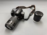 a camera with a lens attached to it next to a cup