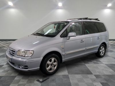 la photo d'un monospace argenté garé dans un garage
