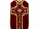 a close up of a red and gold cross on a white background