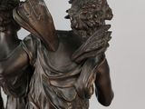 bronze statue of a woman holding a fan and a man holding a book