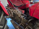 a red tractor that is parked in a garage