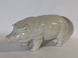 figurine en porcelaine représentant un cochon sur fond blanc