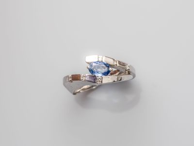 a close up of a silver ring with a blue topaz stone