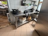 un réfrigérateur en acier inoxydable dans une cuisine dotée de nombreux plans de travail