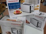 Trois cartons de grille-pain sont empilés sur une table dans un magasin.