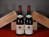 two bottles of red wine sitting next to each other on a table